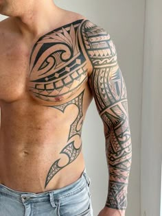 a man with tattoos on his chest and arm