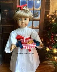 a doll is standing next to a christmas tree and holding a cookie box with cookies in it