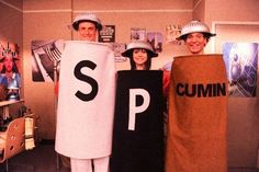 three people dressed up in costumes and hats holding signs that spell out the word s p