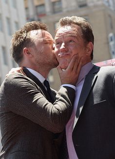 two men in suits kissing each other on the hollywood walk of fame