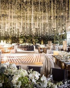 an indoor dining area with tables, chairs and chandelier hanging from the ceiling