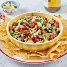 a bowl filled with salsa surrounded by tortilla chips and guacamole