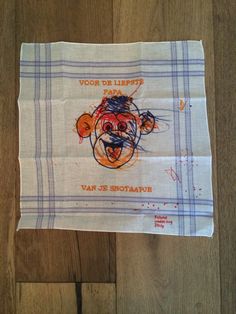 a piece of cloth with an image of a monkey on it sitting on a wooden floor