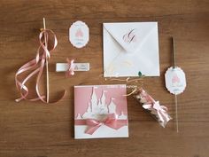 pink and white wedding stationery on wooden table