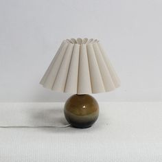 a table lamp sitting on top of a white cloth covered floor next to a wall