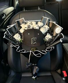 a hat and flowers in the back seat of a car with other items on it