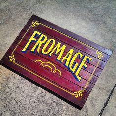 a wooden sign that says fromage on it