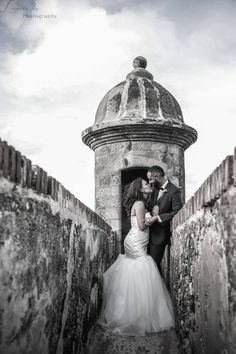 a bride and groom are standing in an old gated entrance to their wedding day