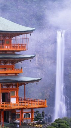 an orange building with a waterfall in the background