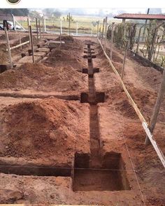 an old trench dug in the ground with fencing around it and dirt on the ground