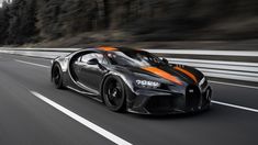 a black and orange bugatti driving down the road with trees in the background