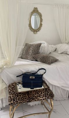 a leopard print bench in front of a white bed