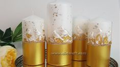 four candles with gold and white decorations on them