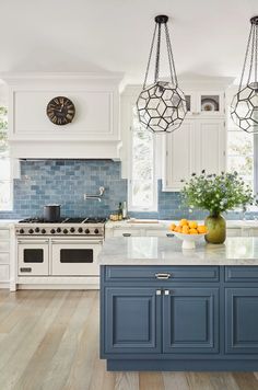 a blue and white kitchen with an island in front of the stove top, sink and oven