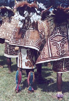 some very pretty horses standing next to each other in the grass with decorations on their backs