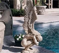 a bird statue sitting next to a swimming pool