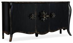 an old black cabinet with metal decorations on the doors and drawers is isolated against a white background