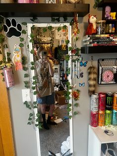 a woman taking a selfie in the mirror with her dog and cat toys on the floor