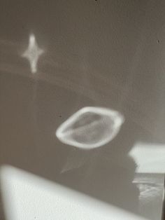 the shadow of a person's hand on a wall next to a white object