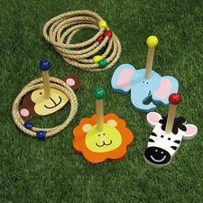 several wooden toys are laying on the grass with rope and beads around them, including an elephant, giraffe, zebra, monkey