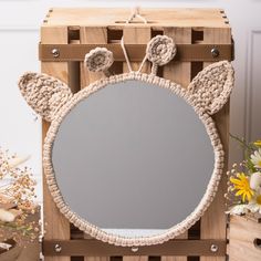 a wooden box with a mirror and some flowers