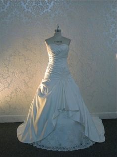 a wedding dress on display in front of a wall