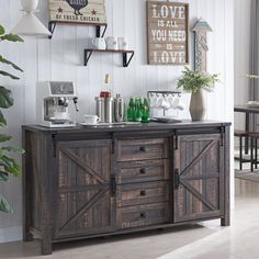 a kitchen area with a wooden cabinet and various items on the counter, along with two potted plants