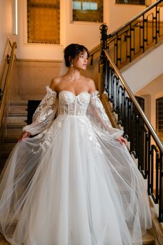 a woman in a wedding dress standing on stairs