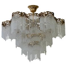 a large chandelier with many lights hanging from it's sides and gold trimmings