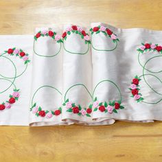 four embroidered napkins with roses on them