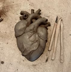 a heart shaped clay sculpture next to some tools