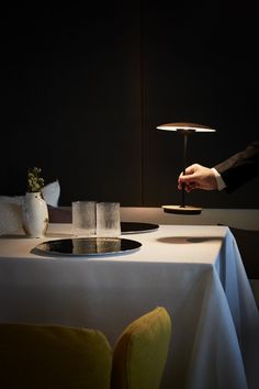 a person holding a wine glass in front of a table