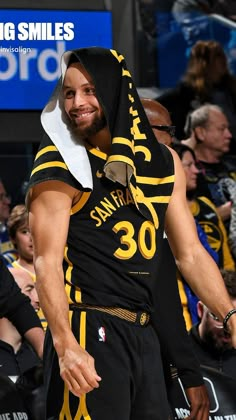 a man with a towel on his head is standing in the middle of a basketball court