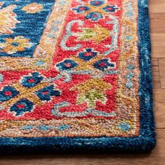 a blue and red rug on the floor with wood floors in the background at home