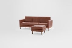 a brown leather couch with ottoman and footstool in front of a white background