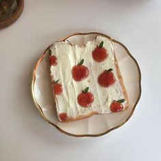 a piece of cake with white frosting and strawberries on it sitting on a plate