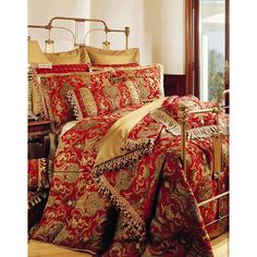 a bed with red and gold comforters in a bedroom