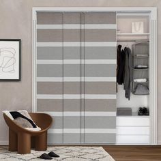 an open closet with sliding doors and clothes hanging on the wall in front of it