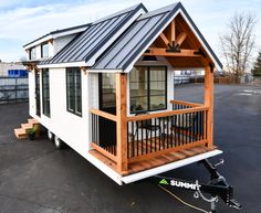 a tiny house on wheels parked in a parking lot