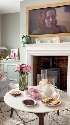 a living room filled with furniture and a fire place in front of a painting on the wall