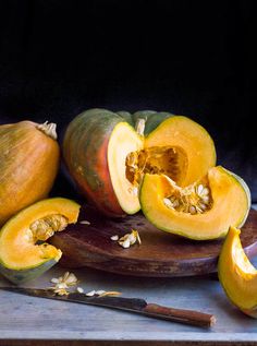 a close up of some fruit on a wooden plate with a knife and spoon next to it