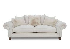 a white couch with several pillows on it