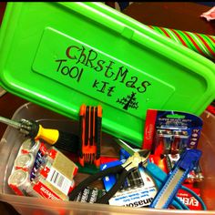 a green christmas tool kit in a plastic container with writing on the side and tools inside