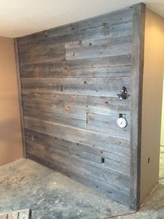 an unfinished room with wood paneling on the wall