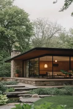 a house that is in the middle of some trees and grass with steps leading up to it