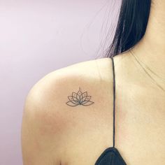 a woman with a tattoo on her shoulder has a lotus flower tattooed on her upper arm