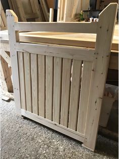 a wooden bed frame sitting on top of a carpeted floor next to a pile of wood