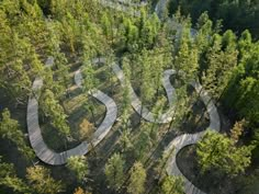 an aerial view of a winding road surrounded by trees