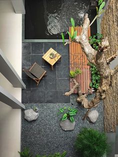 an aerial view of a patio with chairs and tables next to a tree in the yard