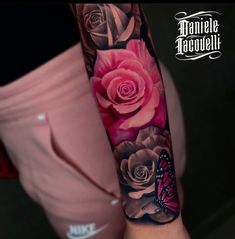 a woman's arm with pink roses and a butterfly on it, next to her leg